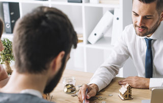 man talking to another man and woman while sitting at a table