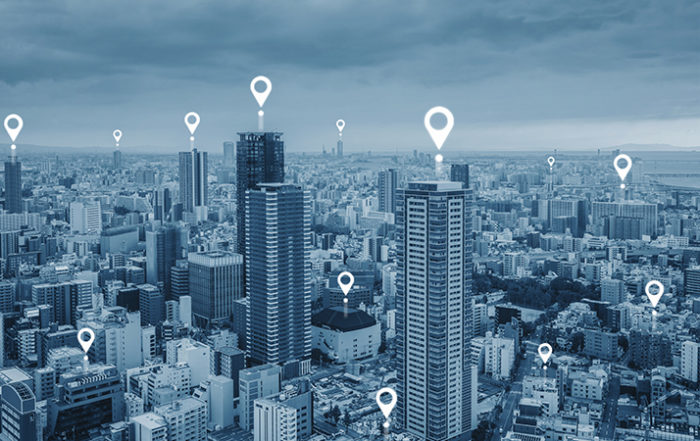 map gps logos on top of tall city buildings